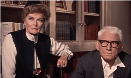 A vintage black and white photo of Spencer Tracy and Katharine Hepburn smiling together during their decades-long partnership.