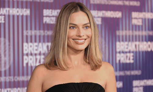Margot Robbie, ranked among the most beautiful women in the world, smiling gracefully in an elegant pose.