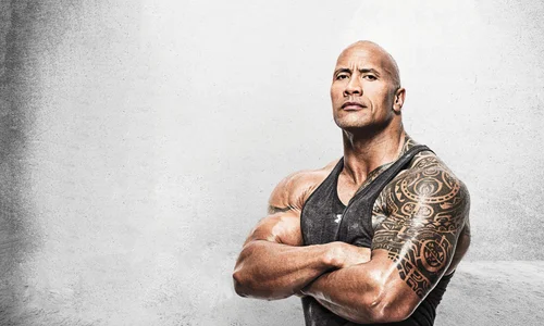 Dwayne "The Rock" Johnson poses with crossed arms in an Under Armour tank top showing his Samoan tattoo.