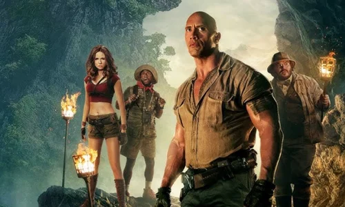 The main cast of "Jumanji: Welcome to the Jungle" standing together in a rocky, jungle cave environment. 