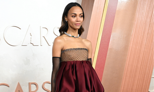 Zoe Saldaña showcases a Saint Laurent couture dress during her 2025 Oscars red carpet appearance.