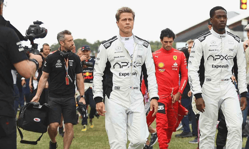 Film shoots scenes during a live Formula 1 Grand Prix.