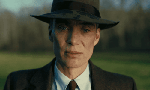 Cillian Murphy as Thomas Shelby in Peaky Blinders, wearing a flat cap and dark overcoat.