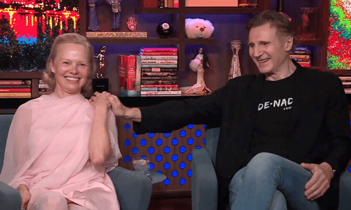 Pamela Anderson and Liam Neeson share a playful moment during a talk show appearance.