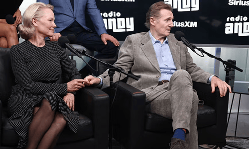 Anderson and Liam Neeson holding hands during a live SiriusXM interview.
