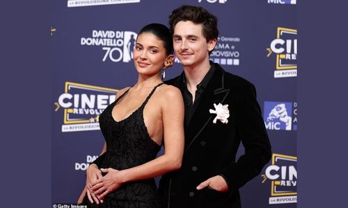 Kylie Jenner and Timothée Chalamet photographed together at a public event, showcasing contrasting fashion styles.