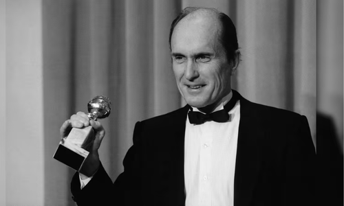 Actor Robert Duvall Black-and-white photo in a tuxedo holding a Golden Globe Award.