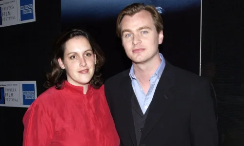 Christopher Nolan and Emma Thomas smiling together at the 2002 Tribeca Film Festival.