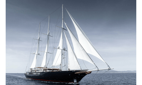 The Koru, Jeff Bezos' massive 417-foot black-hulled sailing yacht, cruising through open blue water.