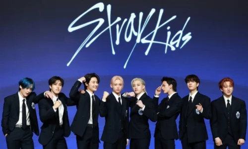 Stray Kids members standing in a professional group lineup representing their status as global K-Pop leaders.
