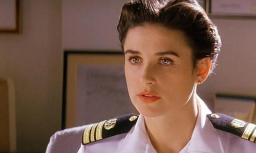 A close-up of Demi Moore in a white military uniform from a classic film scene.