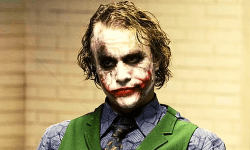 Heath Ledger as the Joker in The Dark Knight, wearing his iconic smudged face paint and purple coat.