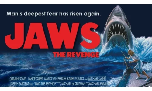 Official movie poster for Jaws The Revenge featuring a great white shark lunging from the ocean.