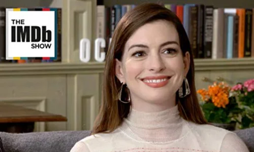 A close-up headshot of Anne Hathaway smiling