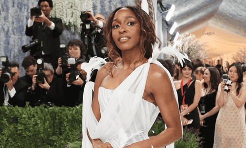 Ayo Edebiri in an ethereal white Chanel gown with delicate feathers and a long braid at the 2026 Met Gala.