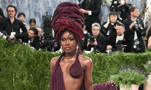 Rapper Doechii in a burgundy Marc Jacobs wrap dress and matching turban headpiece for the "Fashion is Art" theme.