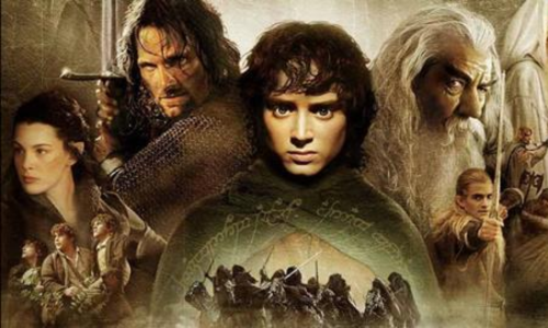 The Fellowship members walking along a majestic mountain ridge in The Lord of the Rings.