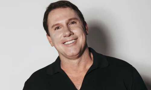 Author Nicholas Sparks smiling outdoors in a casual shirt.