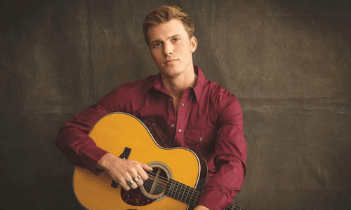 Parker McCollum performing live with his guitar at the MGM Grand Garden Arena.