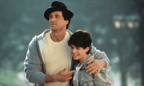 Sylvester Stallone as Rocky Balboa putting his arm around his real-life son Sage Stallone in a scene from Rocky V.