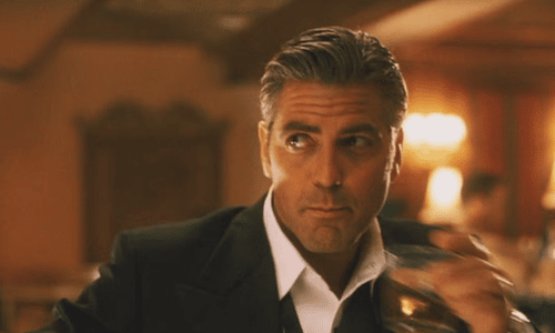 George Clooney starring as Danny Ocean surrounded by cast members in a scene from Ocean's Eleven.
