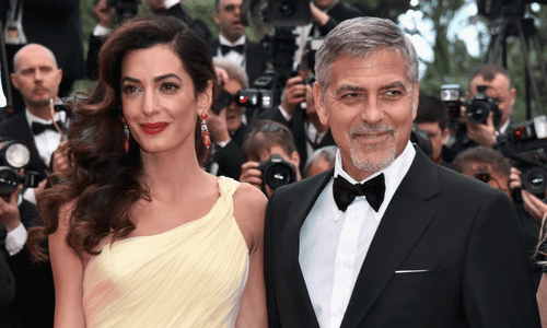 A close-up shot of George Clooney speaking expressively during a media interview.