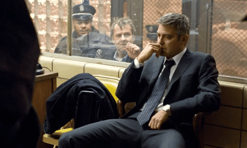 George Clooney wearing a dark suit in a tense moment from the dramatic thriller Michael Clayton.