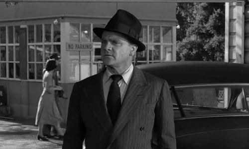 James Cagney wearing a fedora and pinstripe suit in a classic black-and-white gangster film scene