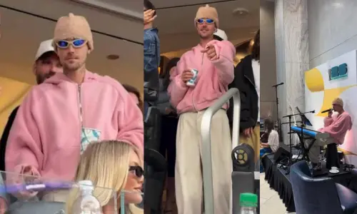 Justin Bieber wearing a pink sweatshirt and tan beanie.