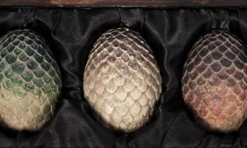 Three replica Game of Thrones dragon eggs inside a wooden chest.