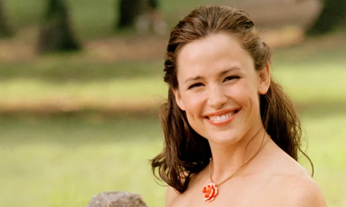 Jennifer Garner smiling outdoors against a blurred green background.