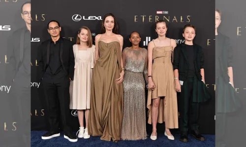 Angelina Jolie poses at the Eternals premiere with children Maddox, Vivienne, Zahara, Shiloh, and Knox in formal attire.