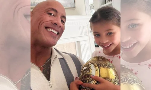 Dwayne Johnson smiles beside his daughter, who holds a golden Cleopatra egg prop from Red Notice.