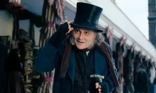 Ebenezer Scrooge walking through a snowy Victorian street