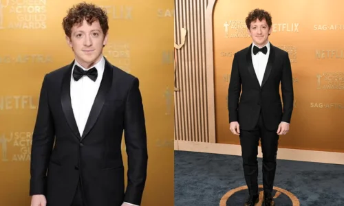 Ethan Slater standing in a black tuxedo at an awards event