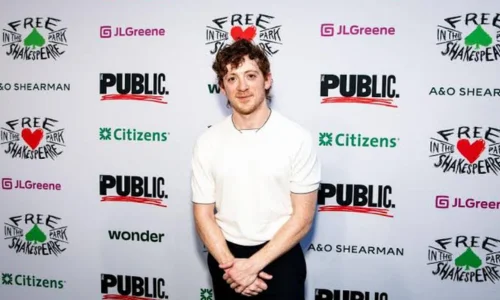 Ethan Slater wearing a white shirt at a Free Shakespeare in the Park event
