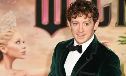 Ethan Slater wearing a green velvet tuxedo at a Wicked red carpet event