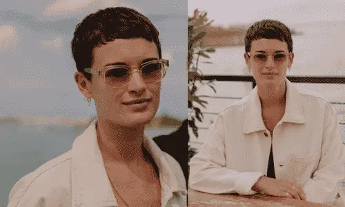 Director Georgia Oakley wearing tinted sunglasses and a white casual jacket while sitting outdoors.