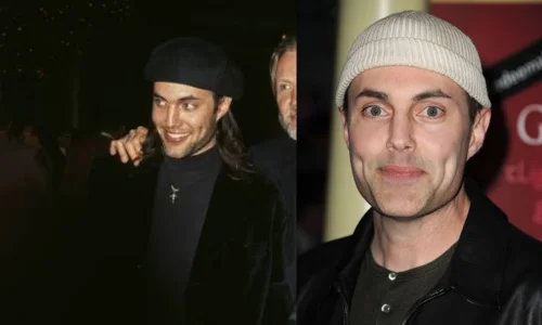 James Haven wears a beige ribbed beanie, grey henley, and black leather jacket while smiling slightly in a close-up portrait.