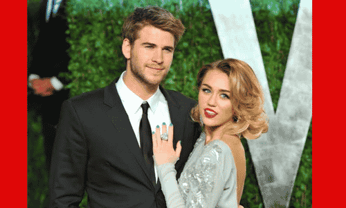 Miley Cyrus and Liam Hemsworth posing together at a public event