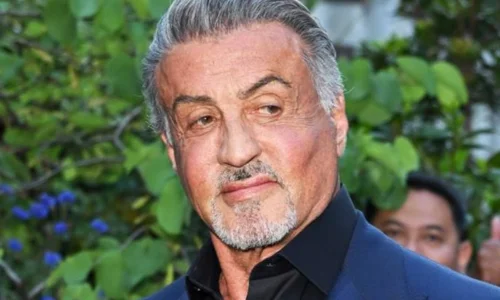 Sylvester Stallone posing at a public event as the writer and star of Rocky
