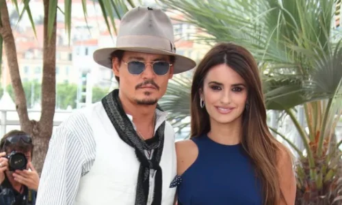 Actors Johnny Depp and Penélope Cruz posing together outdoors.