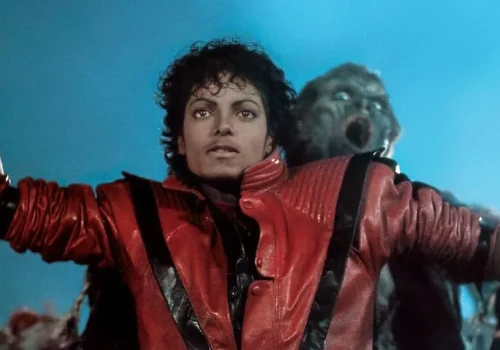 Michael Jackson wearing a red jacket with black stripes in a Thriller music video scene