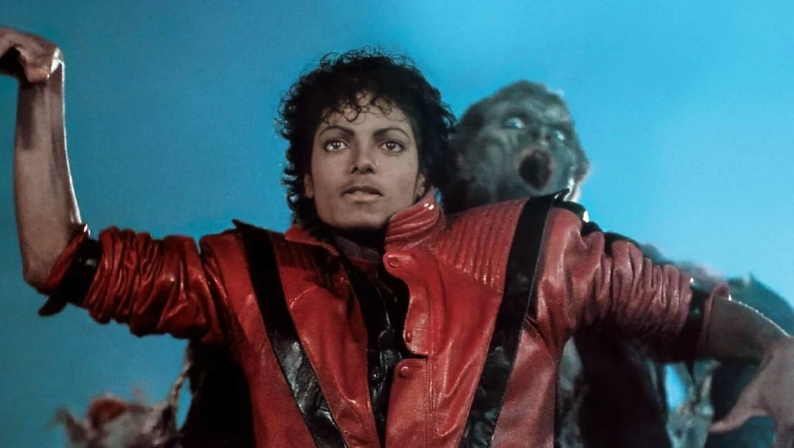 Michael Jackson wearing a red jacket with black stripes in a Thriller music video scene