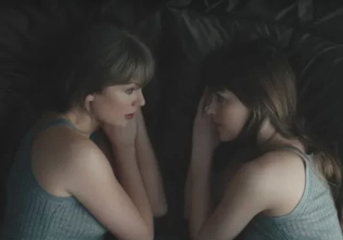 taylor swift lying beside her reflection in a dark, moody music video scene