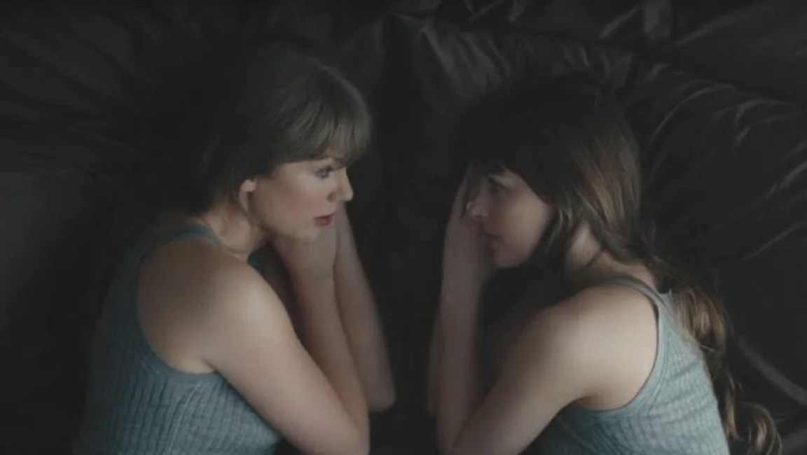 taylor swift lying beside her reflection in a dark, moody music video scene